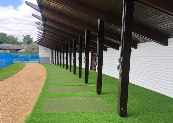 Austin Covered outdoor tee line with light green synthetic grass boxes inside a dark green synthetic grass strip